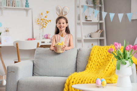 Cute little girl wearing bunny ears with Easter basket at home