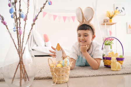 Cute little boy with Easter baskets and rabbit at home