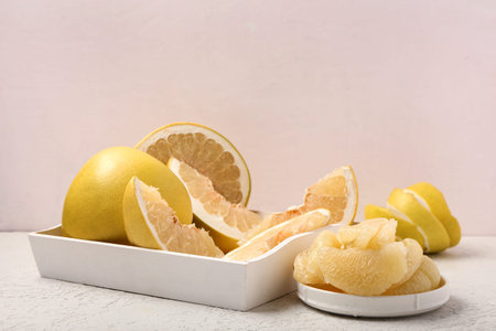 Box and plate with pomelo pieces on white table