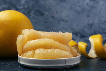 Plate with pomelo pieces on blue grunge backgroundの写真素材