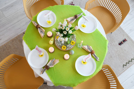 Beautiful table setting with burning candles and tulip flowers for International Women's Day...