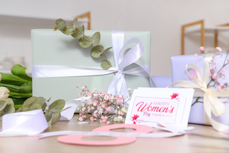 Beautiful gift boxes, flowers and greeting card for International Women's Day on wooden tableの写真素材