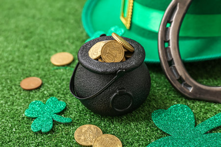 Pot with golden coins, horseshoe and leprechaun hat on grass. St. Patrick's Day celebrationの写真素材