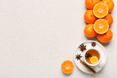 Sweet mandarins and cup of tea with star anise on white backgroundの写真素材