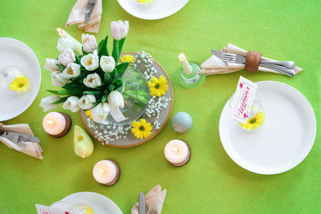 Beautiful table setting with burning candles and tulip flowers for International Women's Day celebrationの写真素材