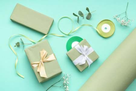 Gift boxes with wrapping paper and gypsophila flowers on turquoise background. International Women's Dayの写真素材