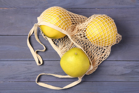 String bag with fresh pomelo fruits on blue wooden backgroundの写真素材