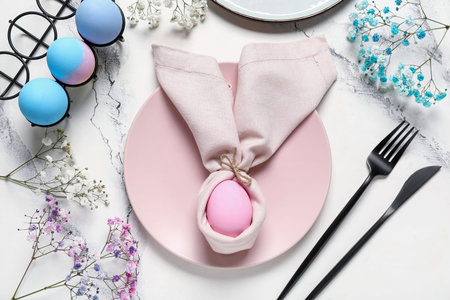 Beautiful table setting for Easter with eggs and flowers on white grunge background