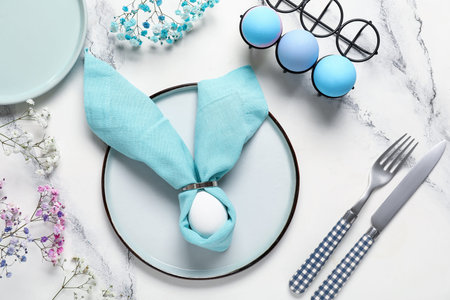 Beautiful table setting for Easter with eggs and flowers on white grunge background