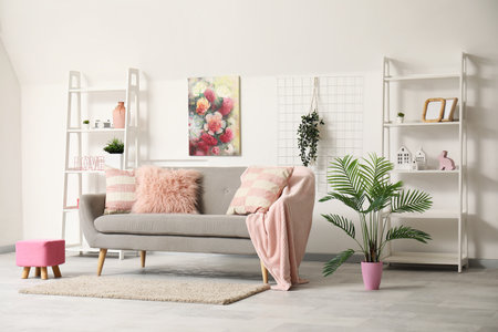 Loft style interior of living room with stylish sofa, houseplant, shelves and pictureの写真素材