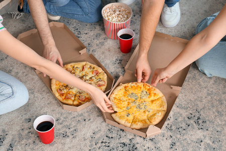 Group of young friends with tasty pizza at home, closeupの写真素材