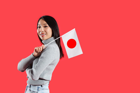 Young Asian woman with flag of Japan on red backgroundの写真素材
