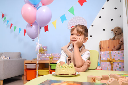 Little boy with cake celebrating Birthday at home