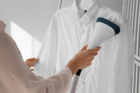 Woman steaming white shirt at home, closeupの写真素材