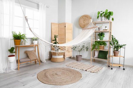 Interior of living room with green plants and hammockの写真素材