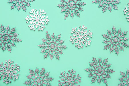 Many Christmas decorative snowflakes on turquoise background