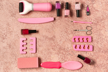 Set of professional tools for pedicure with nail polishes on grunge pink backgroundの写真素材