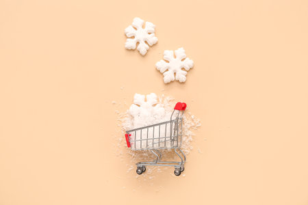 Shopping cart with Christmas decorative snowflakes on beige backgroundの写真素材
