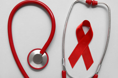 Red ribbon with stethoscope on light background. AIDS Day conceptの写真素材