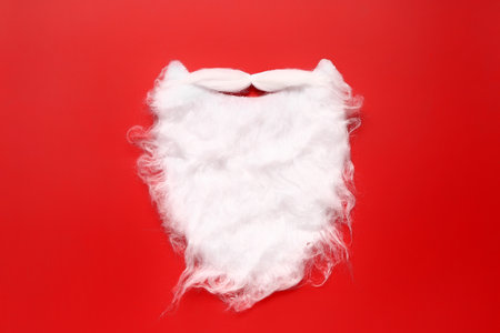 Santa beard made of cotton wool on red backgroundの写真素材