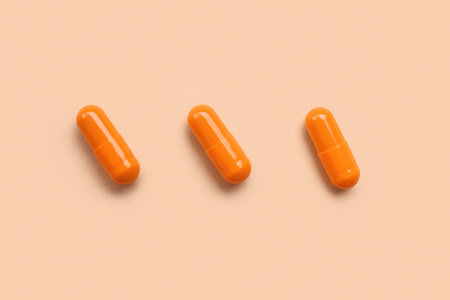 Orange medical capsules on beige backgroundの写真素材