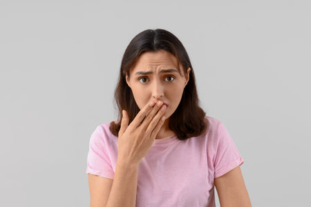 Worried young woman with dandruff on light background, closeupの写真素材