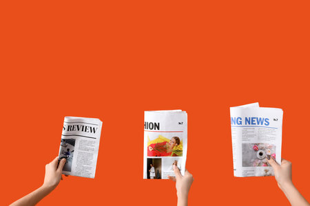Women with newspapers on orange backgroundの写真素材