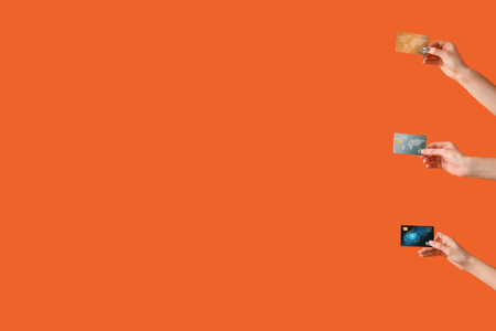 Women with credit cards on orange backgroundの写真素材