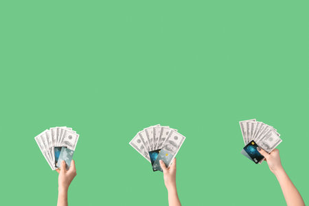 Women with credit cards and dollar banknotes on green backgroundの写真素材