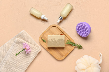 Hair scalp massager with shampoo bar and bottles of cosmetic oil on grunge beige backgroundの写真素材