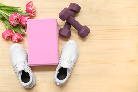 Composition with sports equipment, stylish shoes and tulip flowers on wooden background. International Women's Dayの写真素材