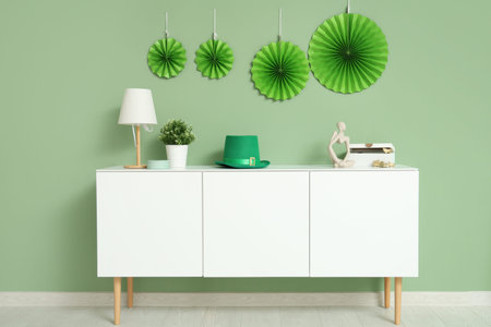 Interior of festive living room with white cabinet and decorations for St. Patrick's Day celebration