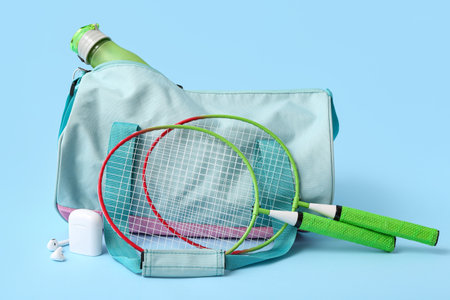 Sports bag with sportswear and tennis rackets on blue backgroundの写真素材