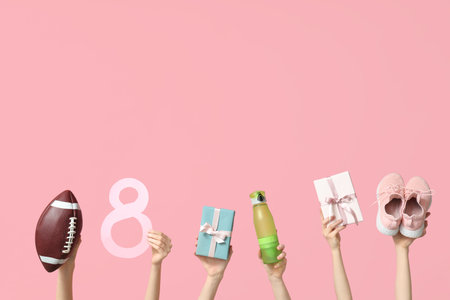 Female hands with sports equipment, paper figure 8 and gifts for International Women's Day on pink backgroundの写真素材