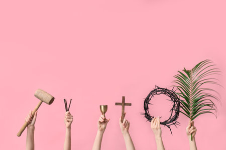 Female hands with wooden cross, crown of thorns and palm leaf on pink background. Good Friday...