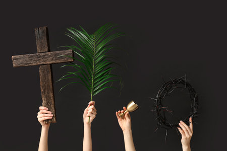Female hands with wooden cross, palm leaf and crown of thorns on dark background. Good Friday conceptの写真素材