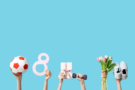 Female hands with sports equipment, shoes, gift box and tulip flowers for International Women's Day on color backgroundの写真素材