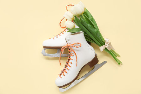 Pair of ice skates and tulip flowers for International Women's Day on color backgroundの写真素材