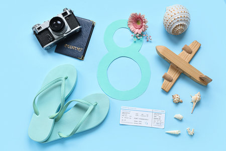 Composition with paper figure 8, ticket, wooden plane and seashells on color background. International Women's Dayの写真素材