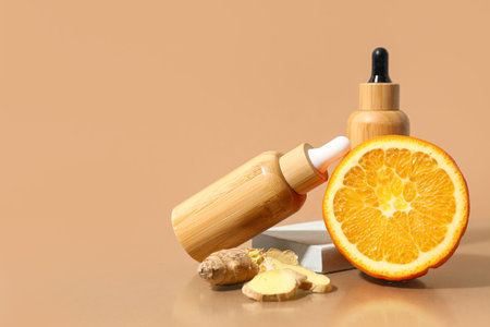 Composition with bottles of essential oil, orange and ginger on color backgroundの写真素材