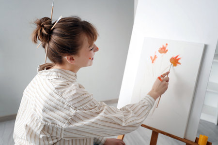 Female artist painting on canvas in workshopの写真素材