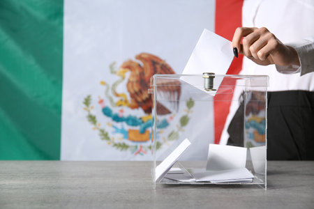 Voting young woman near ballot box against Mexican flag, closeupの写真素材