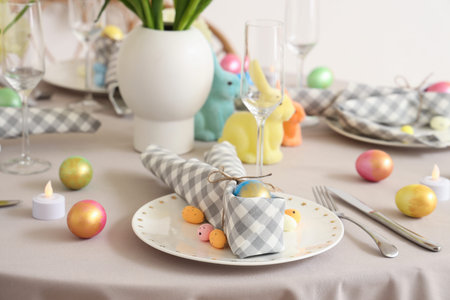 Festive Easter table setting with bunny, cutlery, napkins and painted eggs