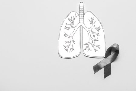 Drawn paper lungs with ribbon on gray background