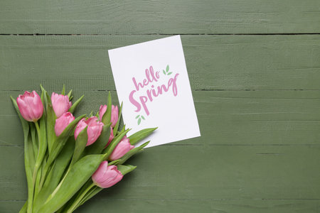 Greeting card with text HELLO SPRING and beautiful pink tulips on green wooden background