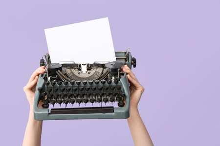 Woman holding retro typewriter with greeting card for International Women's Day on lilac background, closeupの写真素材