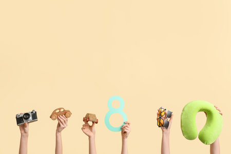 Female hands with paper figure 8, travel pillow, wooden cars and sunglasses on color background. International Women's Dayの写真素材