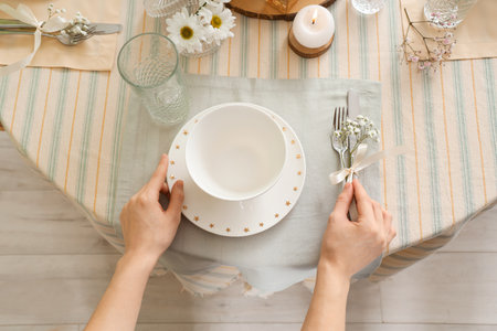 Female hands with beautiful table setting for International Women's Day celebration, closeupの写真素材