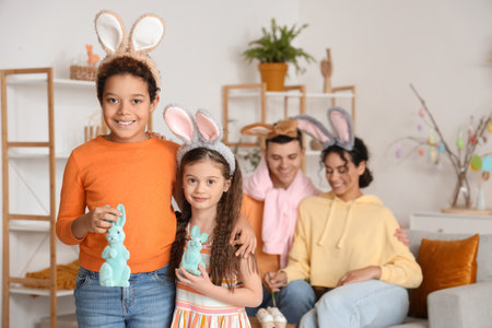 Little children with Easter rabbits and their parents at homeの写真素材