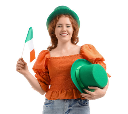 Young redhead woman with Leprechaun hat and flag of Ireland on white background. St. Patrick's Day celebrationの写真素材